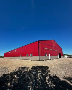 red barn with metal roofing and siding on a blue sky day 