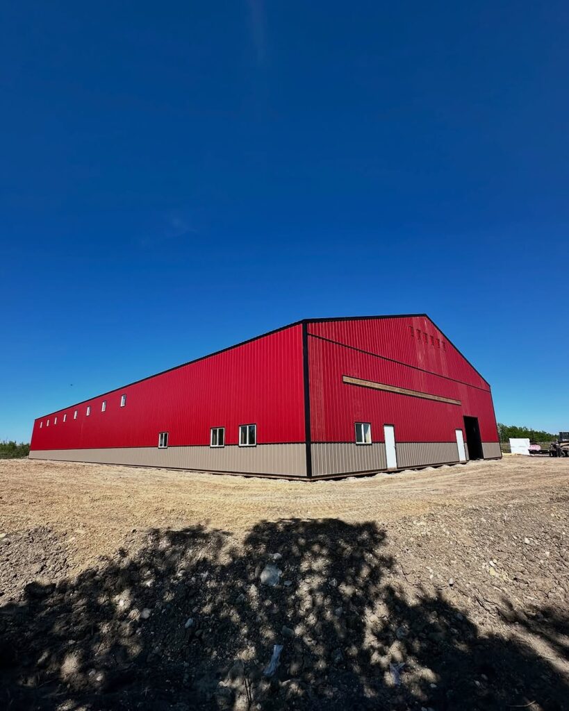barn built of red metal siding and black metal roofing
